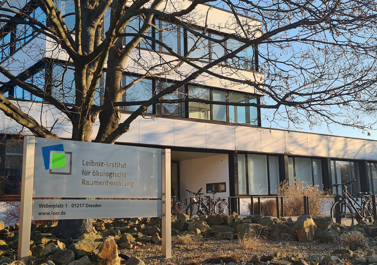 Die Fotografie zeigt das Gebäude des Leibniz-Instituts für ökologische Raumentwicklung in Dresden. Die davor befindlichen Bäume sind ohne Laubblätter (Winteraufnahme).